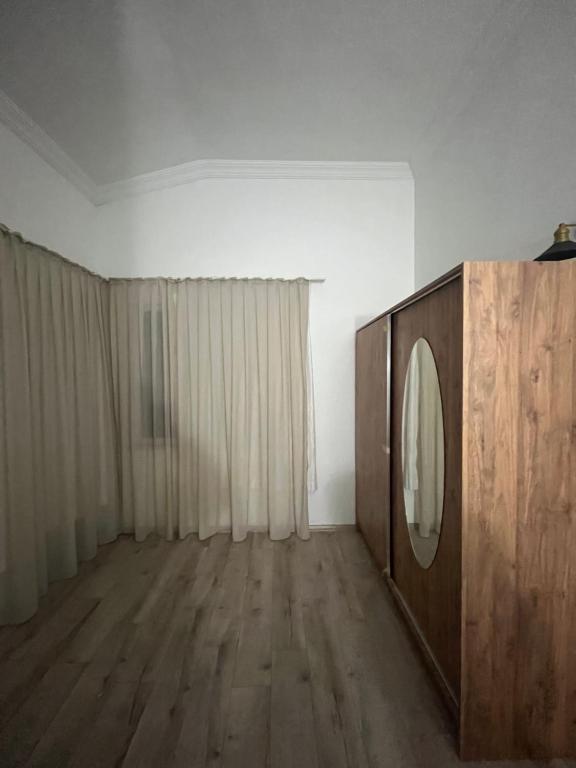 a room with a mirror and a wooden dresser at Merkezi Hijyenik 3+1 Daire in Antalya