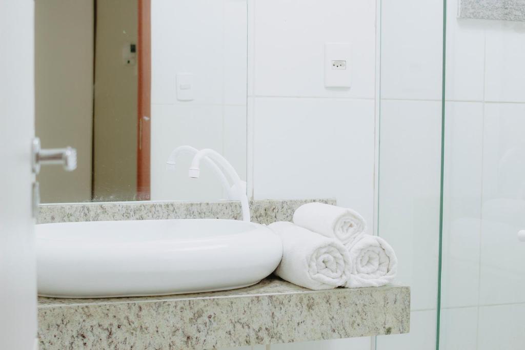 a bathroom with a sink and towels on a counter at Nord Easy Camboinha in Cabedelo