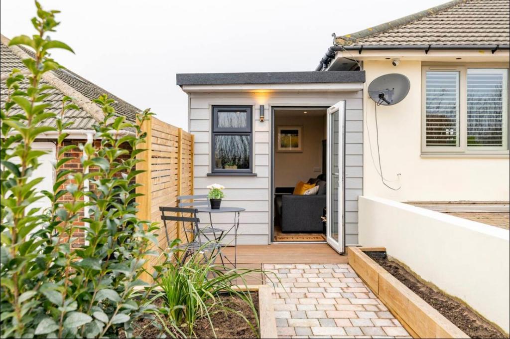 a home with a small patio with a table in front of it at The Hideaway by the sea - free parking in Brighton & Hove