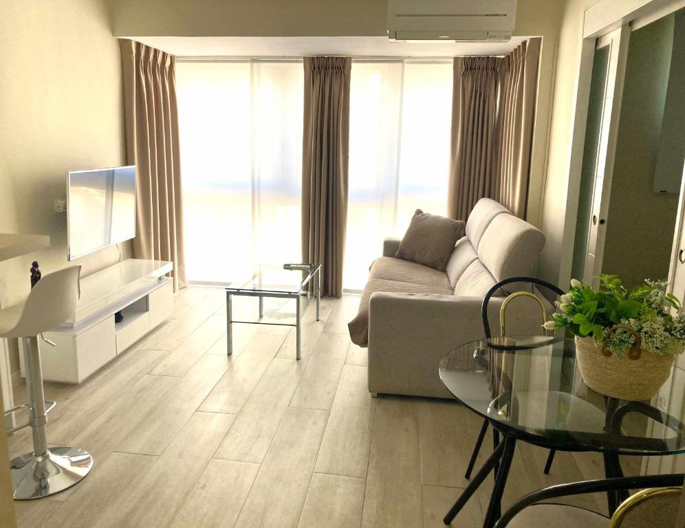 sala de estar con sofá y mesa de cristal en Apartamento La Milla de Oro, en Madrid