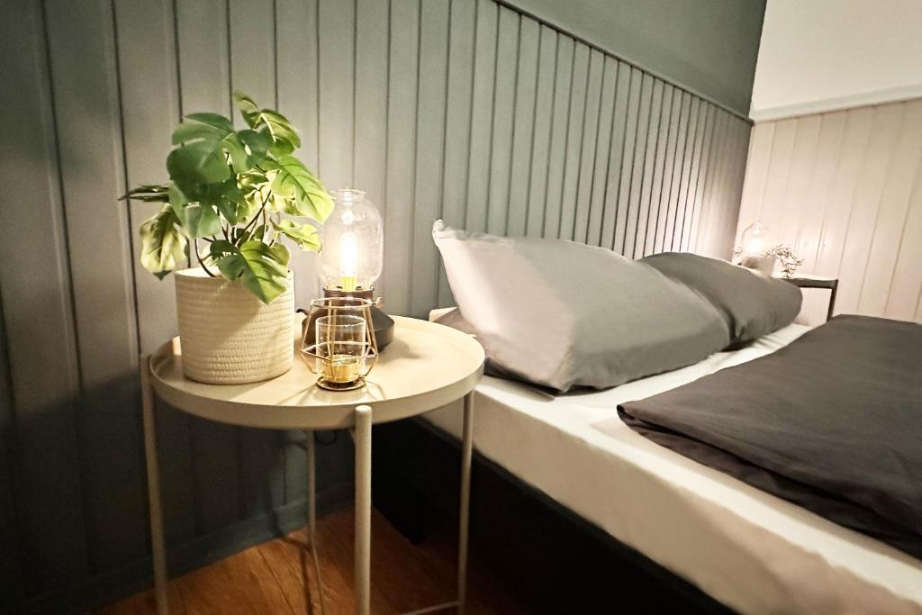a bedroom with a bed and a table with a plant at Ruhiges Office-Apartment mit Küche - BEUYS Apartments Krefeld in Krefeld