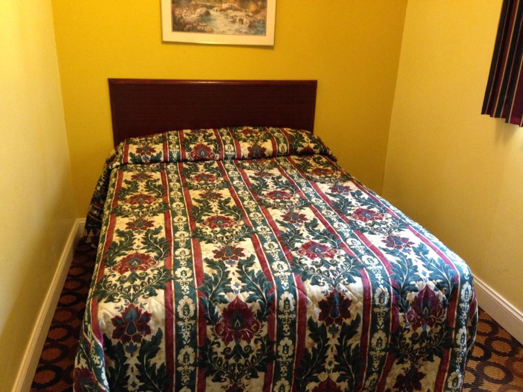 a bed in a bedroom with a colorful bedspread at Flamingo Inn in Seaside Heights