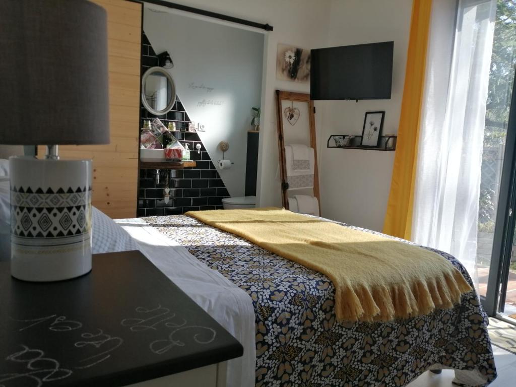 een slaapkamer met een bed met een gele deken erop bij Chambre d'hôte Margot'te in Mimizan