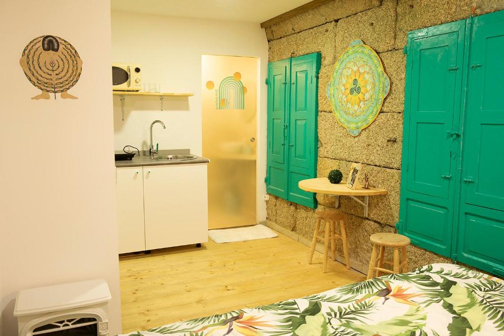 a kitchen with green doors and a sink in a room at 4 Soles in Puente Caldelas