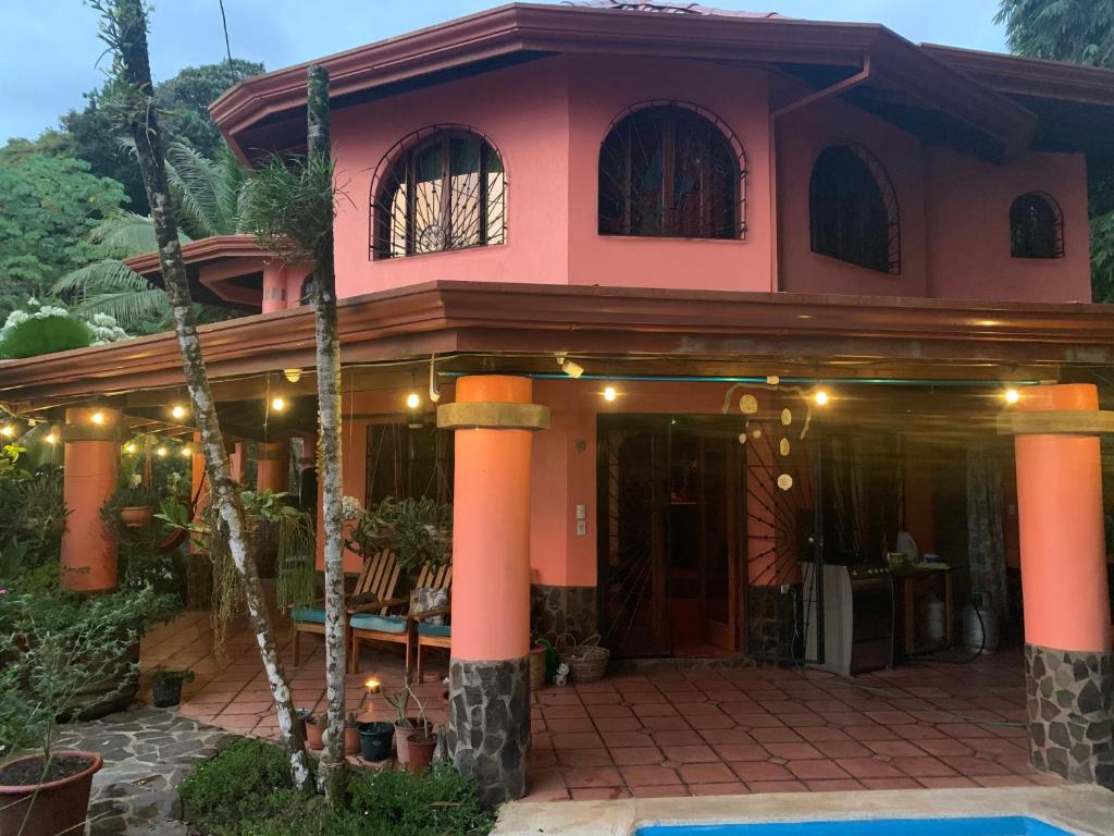 烏維塔的住宿－Casa Papaya，一座粉红色的房子,前面有一棵棕榈树