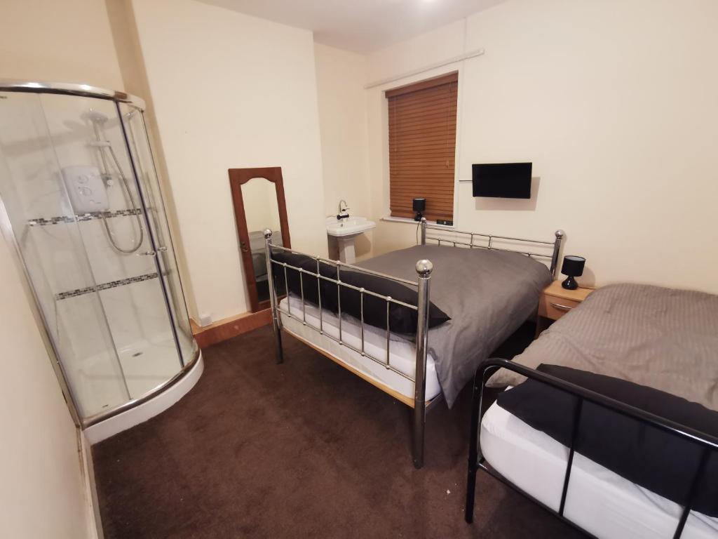Old Trafford City Centre Events 4 Bedrooms 6 rooms sleeps 3 - 8 في مانشستر: غرفة نوم بسريرين ومرآة