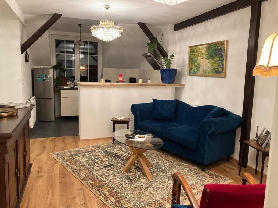 ein Wohnzimmer mit einem blauen Sofa und einem Tisch in der Unterkunft Romantische Ferienwohnung im Grünen in Hohen Neuendorf