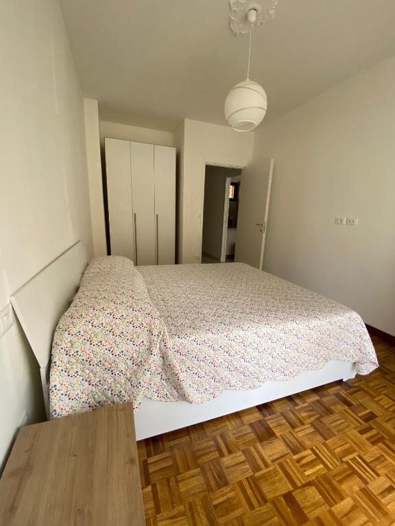 sypialnia z łóżkiem i drewnianą podłogą w obiekcie Casa grigio perla w mieście Vallecrosia