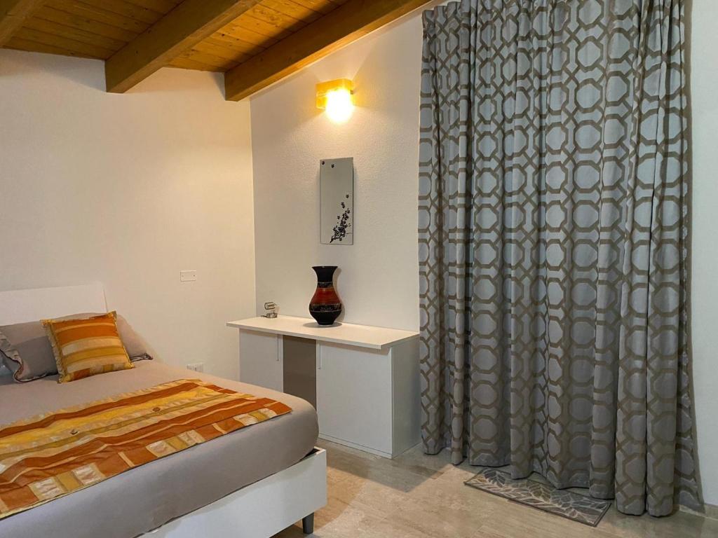 a bedroom with a bed and a window with a curtain at Casa Ghirthalos in Nuoro