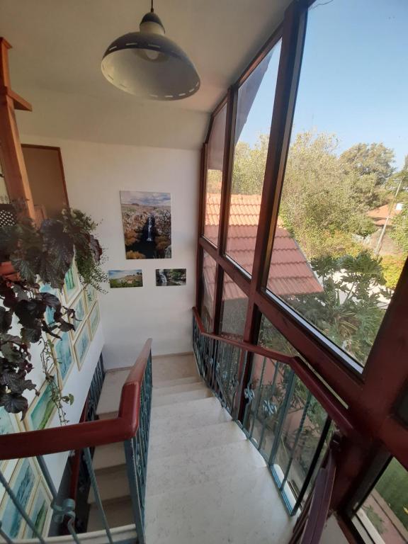 Una escalera en una casa con una gran ventana en אירוח גאלה בגולן, en Katzrin
