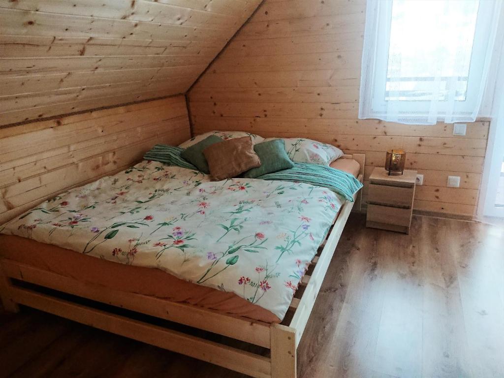 1 dormitorio con 1 cama en una cabaña de madera en Domek Na Starej Cegielni, en Baligród