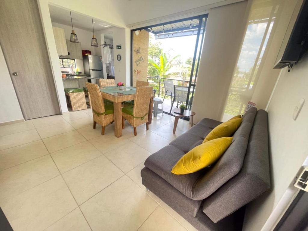 a living room with a couch with a yellow pillow at G308-Hermoso Apartamento en la Tebaida,en condominio campestre in La Tebaida