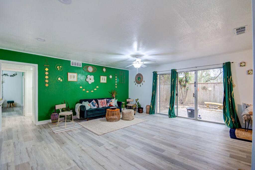 una gran sala de estar con una pared verde en 'Urban Green Living', en Houston