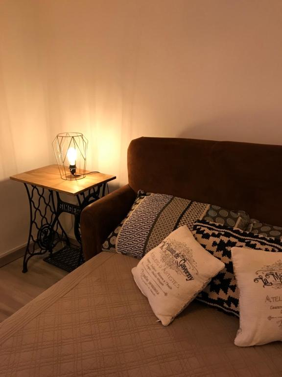 ein Schlafzimmer mit einem Bett und einem Tisch mit einer Lampe in der Unterkunft Le grenier de Manée in Villemoustaussou