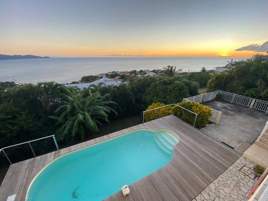 - une piscine sur une terrasse avec vue sur l'océan dans l'établissement Magnifique Villa Collinos avec piscine et jardin, à Schœlcher