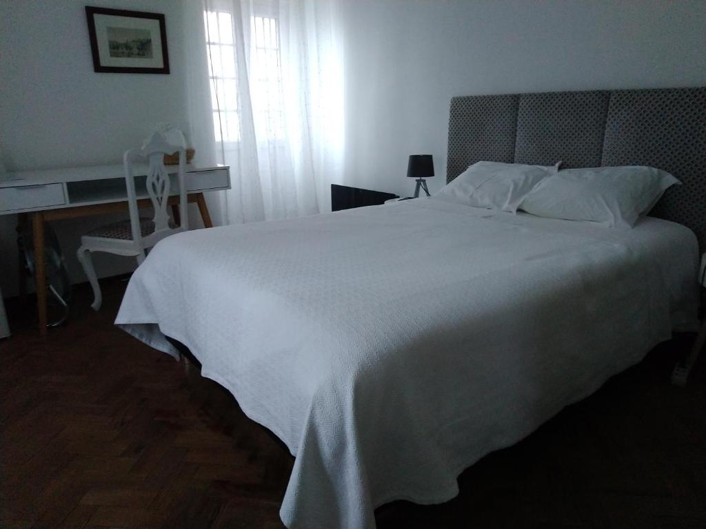 a bedroom with a large white bed with a window at Penaferrim Sintra Rooms in Sintra