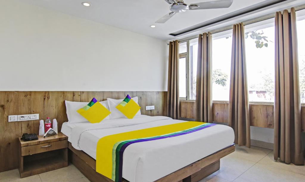 Schlafzimmer mit einem großen Bett mit Holzwänden und Fenstern in der Unterkunft Itsy By Treebo - O3 in Chandīgarh