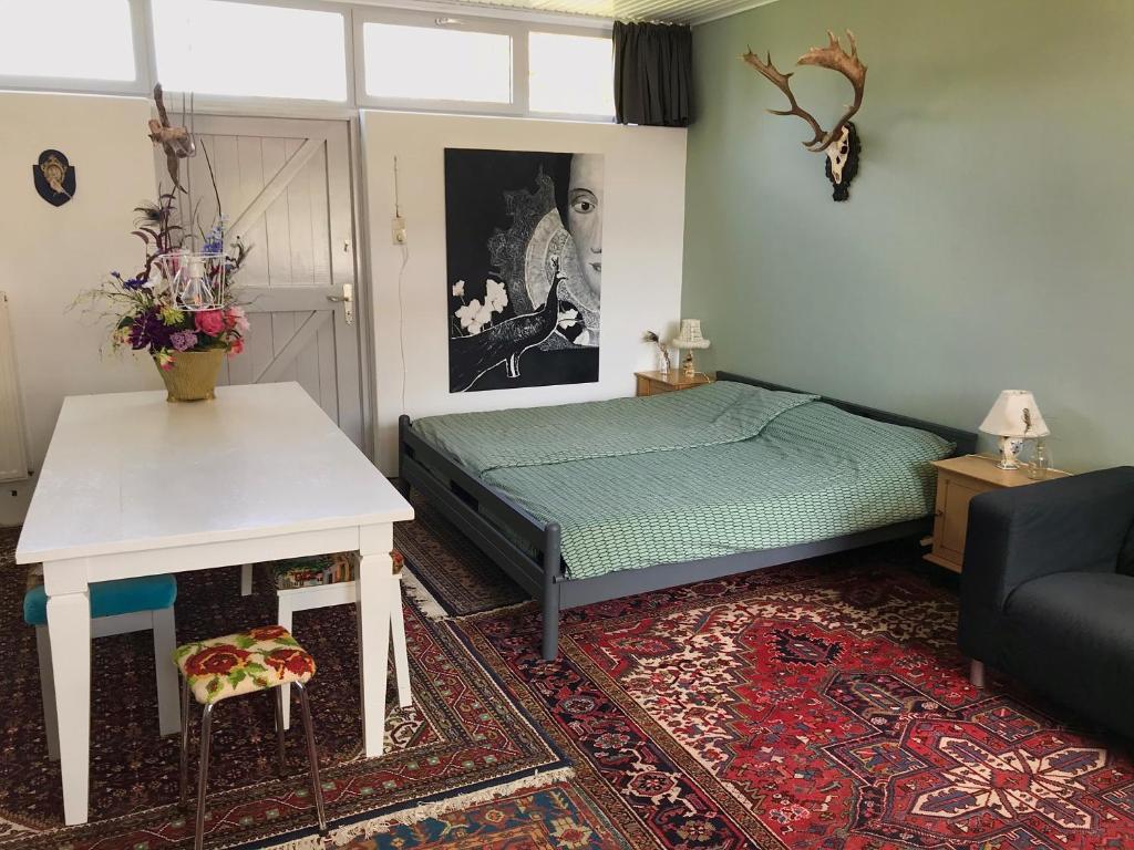 sypialnia z łóżkiem, stołem i kanapą w obiekcie De Vlies w mieście Venray