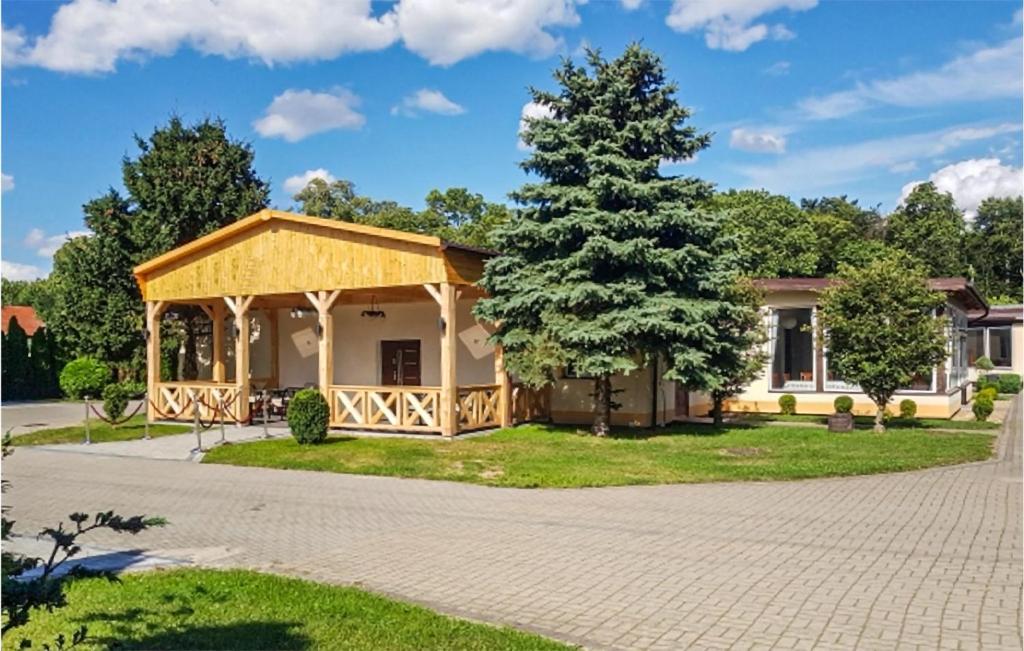 een huis met een veranda en een boom bij Cozy Home In Witnica Chojenska With Kitchen 