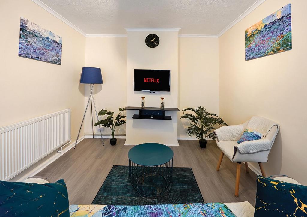 uma sala de estar com um sofá e uma televisão em Three Bed Luxury Home in London em Abbey Wood