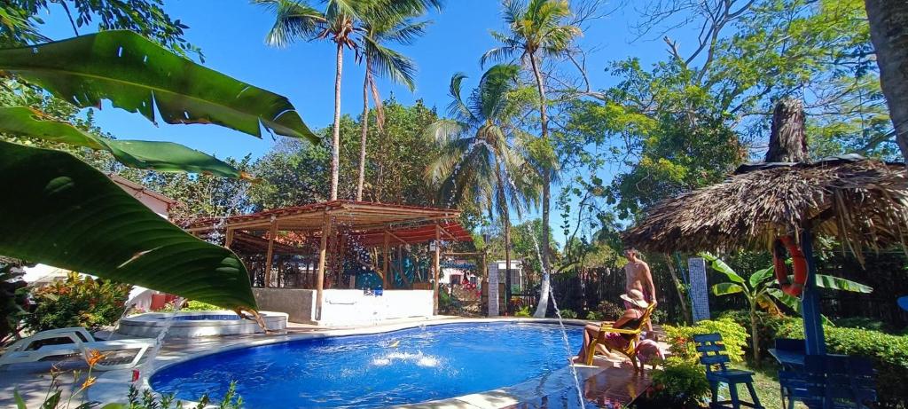 uma piscina num resort com palmeiras em Cabañas San Sebastian Palomino Beach Hostel em Palomino