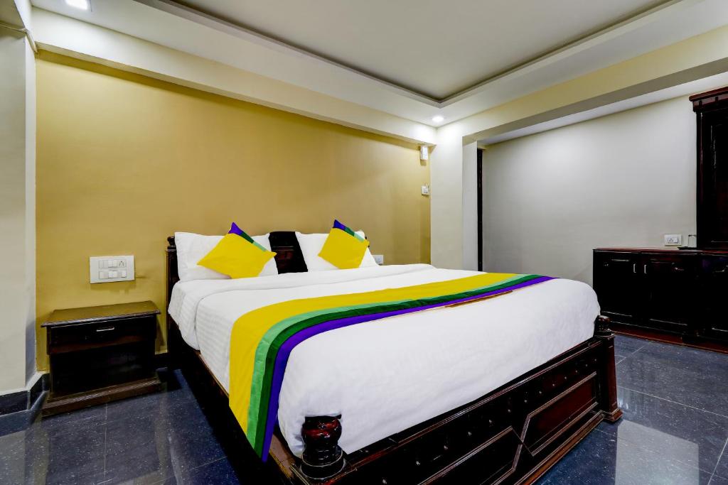 a bedroom with a large bed with colorful sheets and pillows at Itsy By Treebo - Hill View in Madikeri