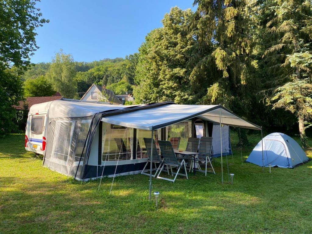Forrás camping في ماغيارهيرتيليند: خيمة وكراسي في حقل بجانب مخيم