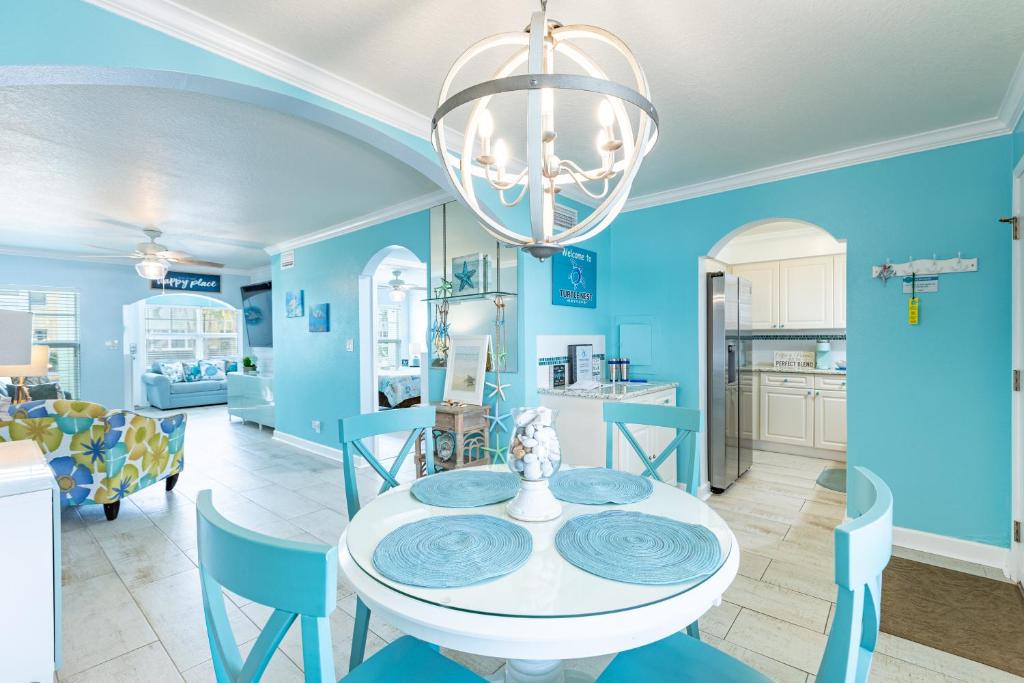 a dining room with a white table and blue walls at Condo in Paradise -Beach and Intracoastal Waterway in Clearwater Beach