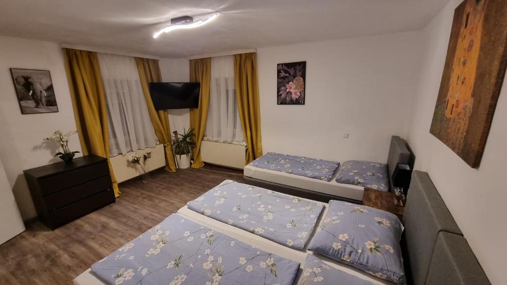 a small room with two beds and a television at Casa Rustica in Graz