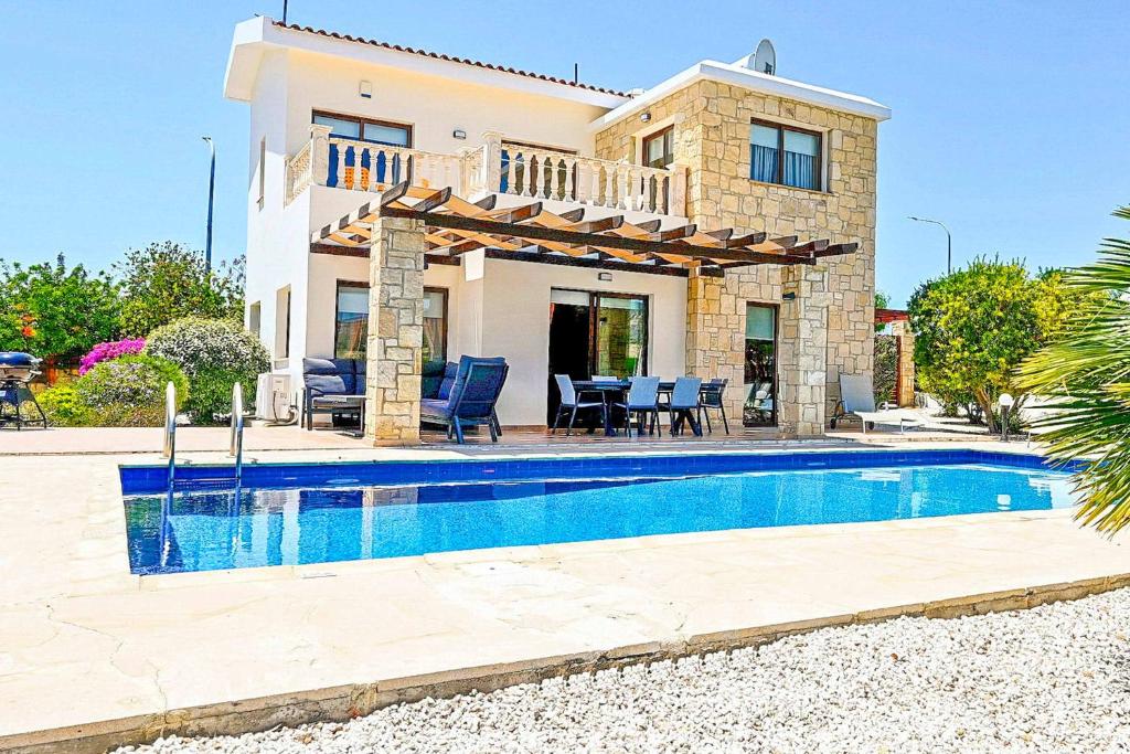 een villa met een zwembad voor een huis bij Villa Olivia Coral in Peyia