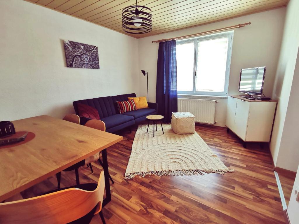 ein Wohnzimmer mit einem Tisch und einem Sofa in der Unterkunft Riverside Appartements in Lieserbrücke