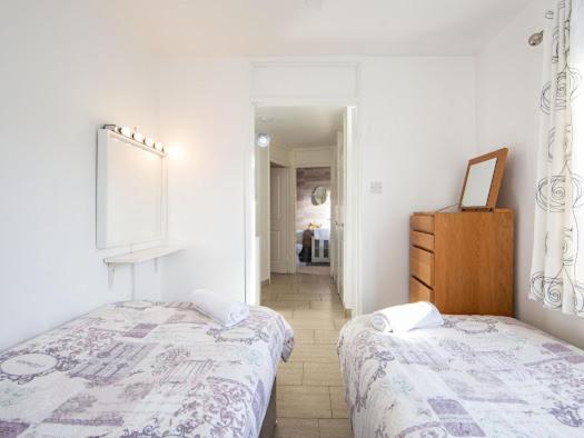 a bedroom with two beds and a dresser in it at Belfast City Apartment in Belfast