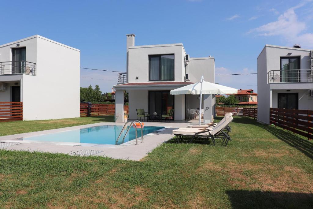 a villa with a swimming pool in front of a house at OLYMPUS Paradise 2 in Skotína