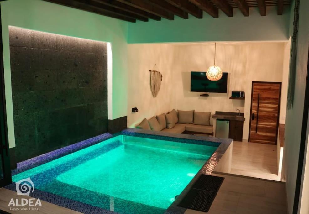a large swimming pool in a living room with a couch at Villa Naj´Lujosa Alberca privada in San Martín de las Pirámides