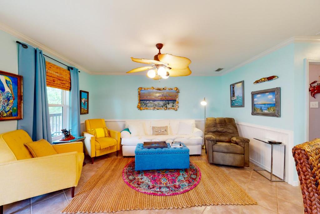 a living room with a white couch and yellow chairs at O'Hara Haven in Dauphin Island