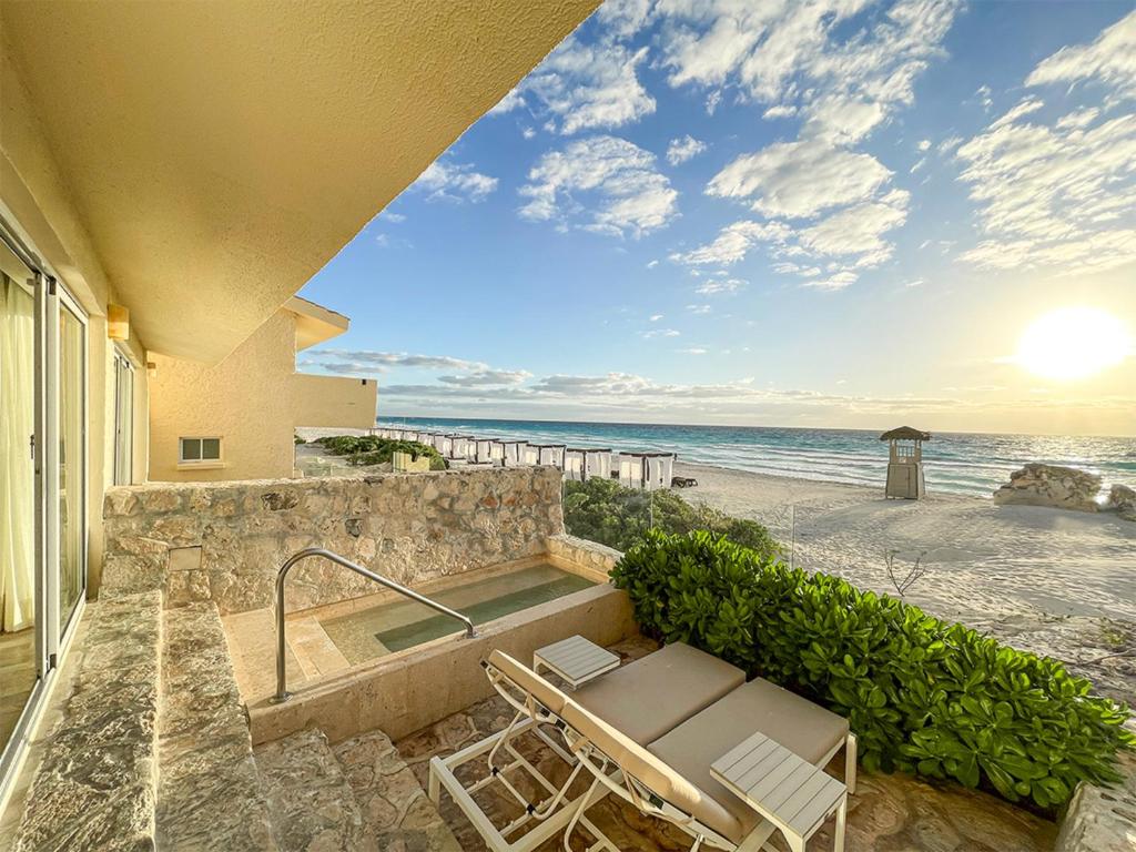 basen z 2 krzesłami i plaża w obiekcie The Villas Cancun by Grand Park Royal - All Inclusive w mieście Cancún