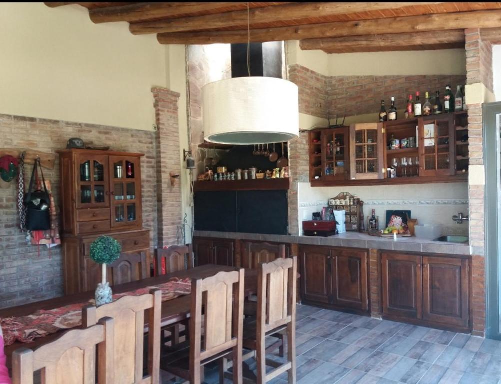 - une cuisine avec des placards en bois, une table et des chaises dans l'établissement La Casa de la Laguna Vistalba, à Luján de Cuyo
