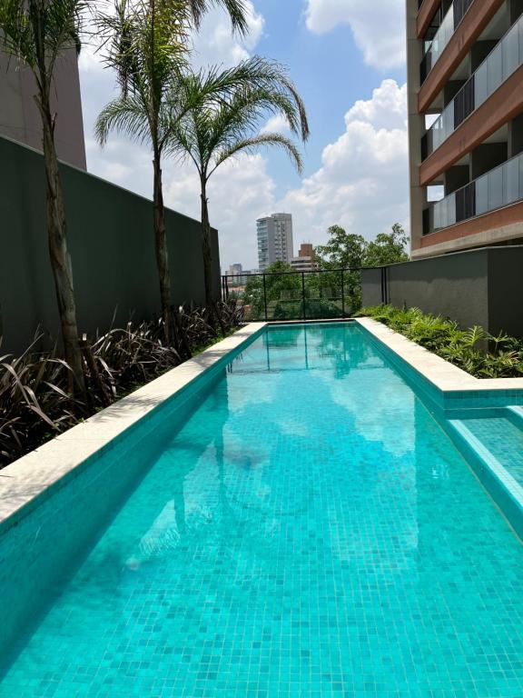 a swimming pool with palm trees on a building at São Paulo - Vila Mariana - Central in Sao Paulo