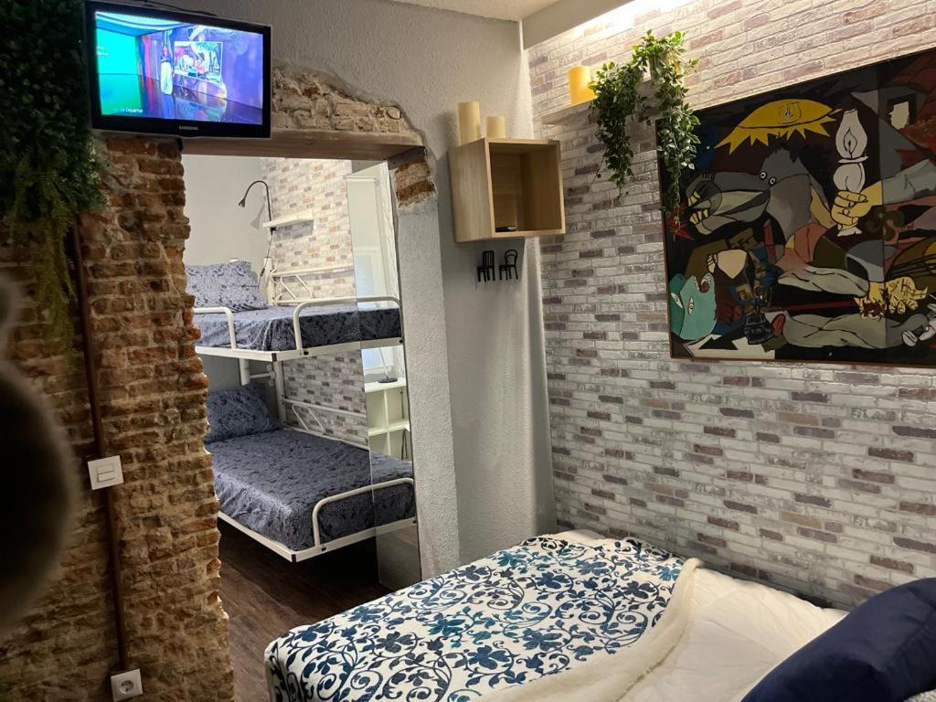 a room with two beds and a tv on a wall at Coqueto apartamento muy céntrico in Madrid