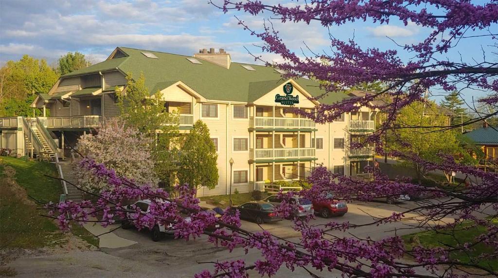 a large house with purple flowering trees in front of it at Grand Wood Suites in Nashville