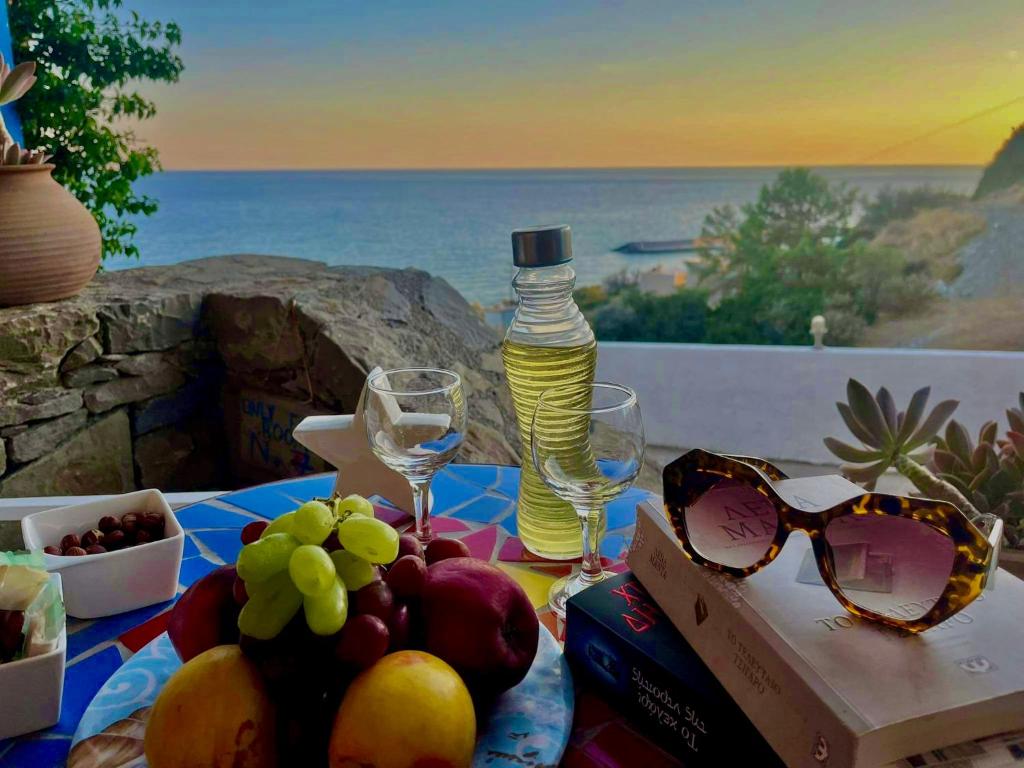 einen Tisch mit Gläsern und Obst sowie eine Flasche Wasser in der Unterkunft Panorama Apartments in Kastrí
