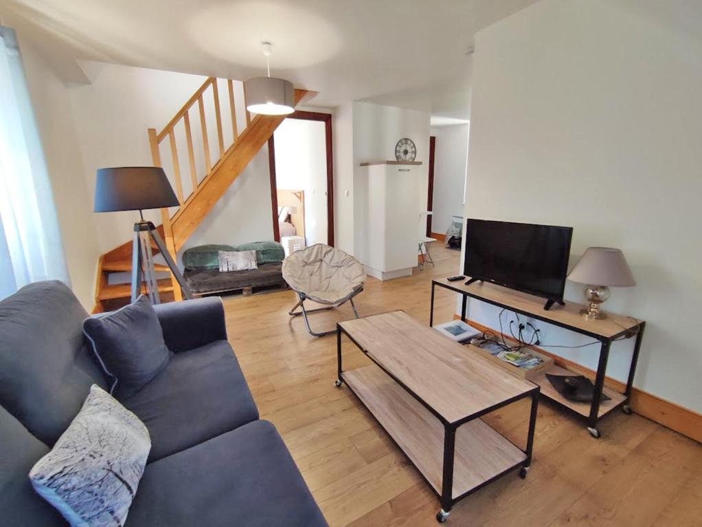 ein Wohnzimmer mit einem Sofa und einem Tisch in der Unterkunft L'Alexiane, Centre Luchon, parking gratuit, wifi in Luchon