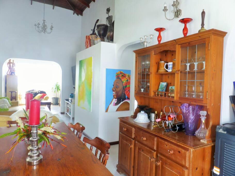 Micoud的住宿－Selen's Apartment in Ti Rocher Micoud Saint Lucia，一间带桌子和大橱柜的用餐室