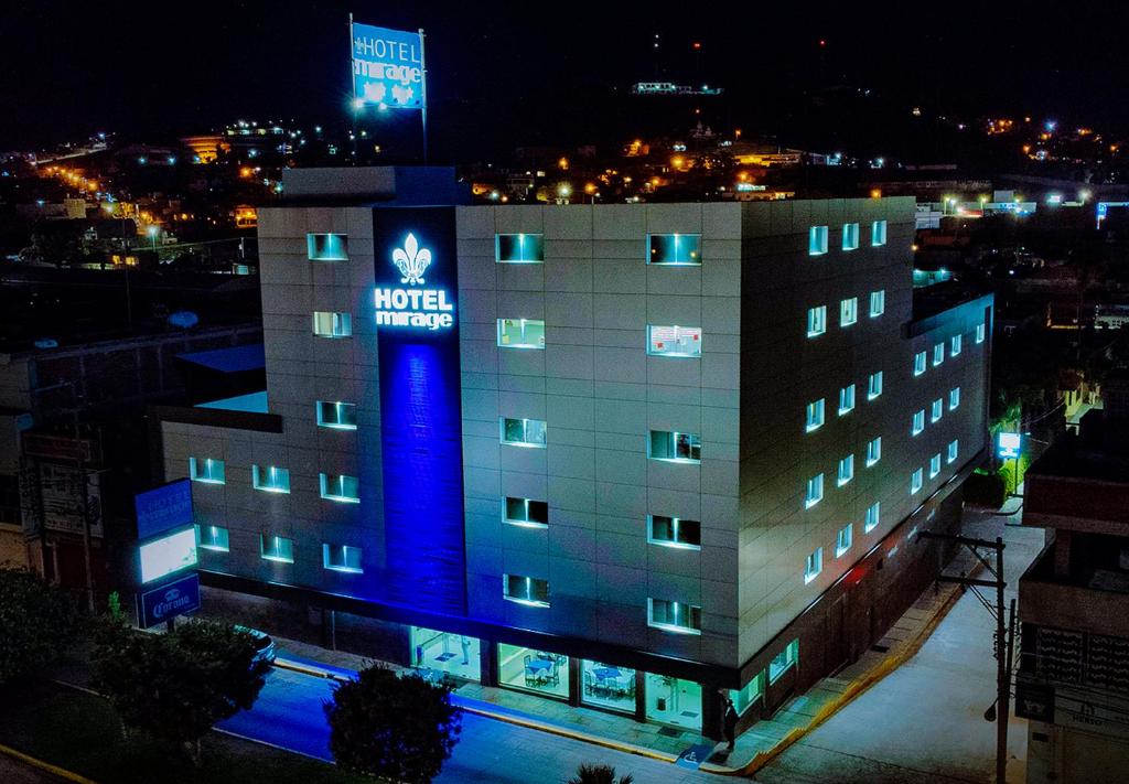 un hôtel avec un panneau bleu sur le côté d'un bâtiment dans l'établissement Hotel Mirage, à La Piedad Cavadas