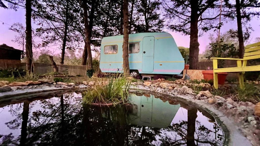 een blauwe caravan geparkeerd naast een waterbak bij Ir por ai Arrábida in Azeitao