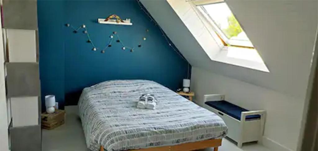 Schlafzimmer mit einem Bett mit blauer Wand in der Unterkunft Chambres chez Emmanuelle entre 2 Abers in Lannilis