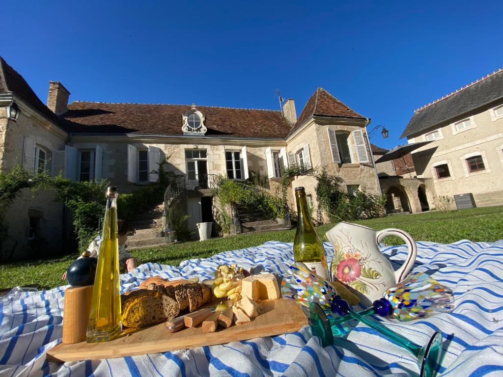 una mesa con dos botellas de champán y un plato de comida en Maison Harmonie en La Châtre