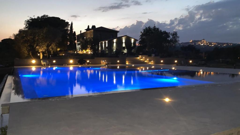 una piscina con iluminación azul por la noche en Villa Paladini, en Montefiascone