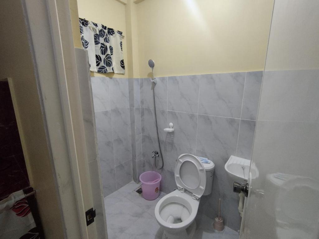 a small bathroom with a toilet and a sink at Jumong's Transient in Bantay