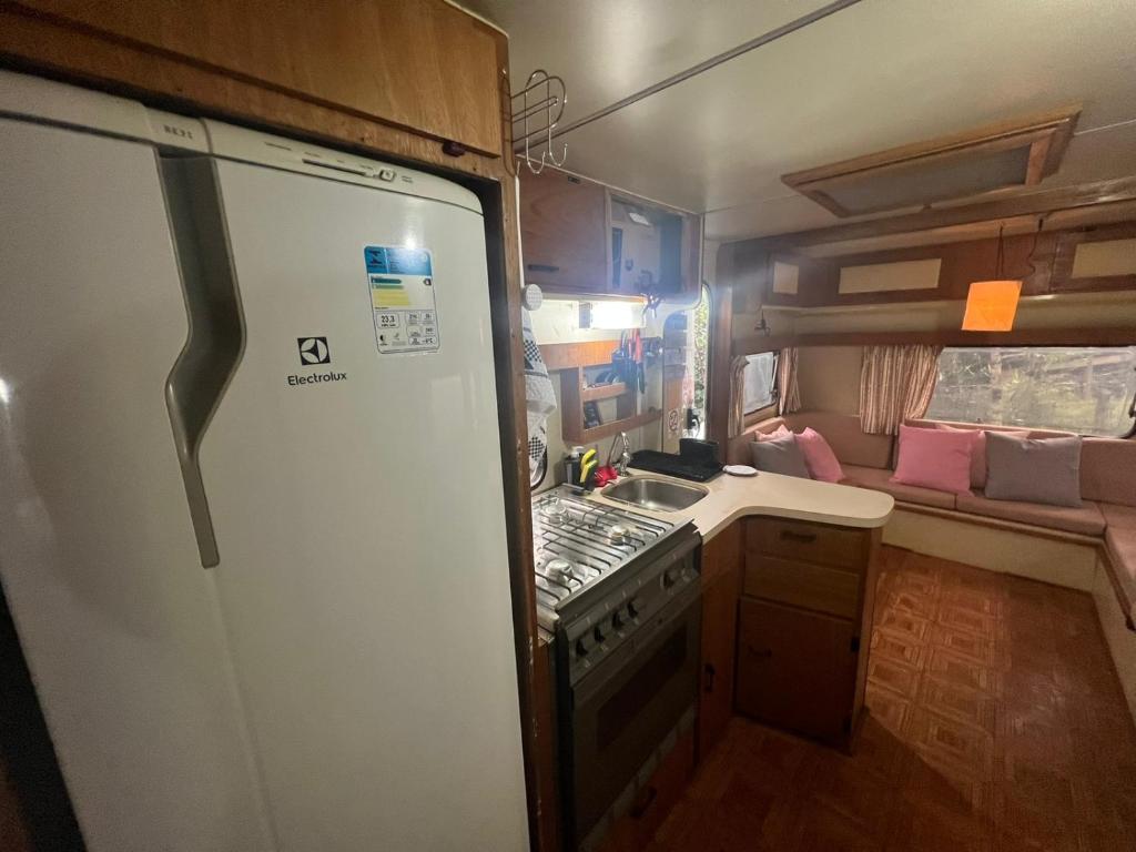 a kitchen with a stove and a sink in a trailer at Trailer Oasis in Lavras Novas